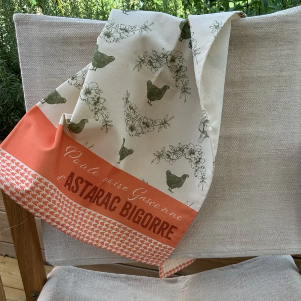 Torchon Poule Noire d'Astarac Bigorre corail et vert foncé sur une chaise